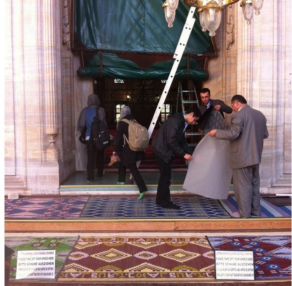 Young women break for prayer and dodge a maintenance team, in one of Fatih's many mosques. Image by Jenna Krajeski. Turkey, 2013.