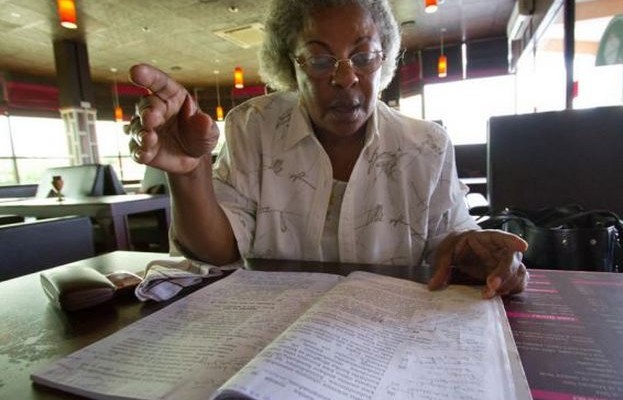 Maria Kashonda pages through her copy of the proposed constitution she helped draft as a member of the Constitutional Review Commission. She says People are putting aside their religious differences to fight for guarantees of rights like education and health, which she says are universal.