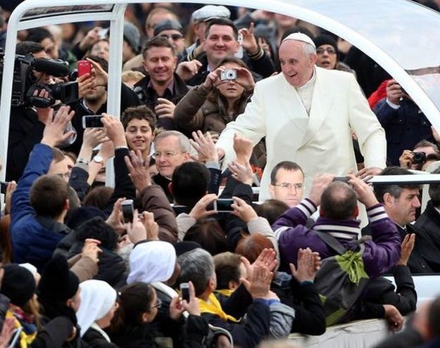 Pope Francis waves to the crowds as he arrives in St. Peter's Square in the Vatican City for his weekly audience. (Franco Origlia / Getty Images)