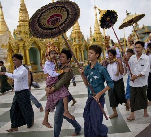 In this April 8, 2014 photo, Buddhist devotees carry their sons and nephews to circumambulate the Shwedagon pagoda in hopes of earning a blessing from Buddha ahead of their ordination as Buddhist monks, in Yangon, Myanmar.(AP Photo/Gemunu Amarasinghe)